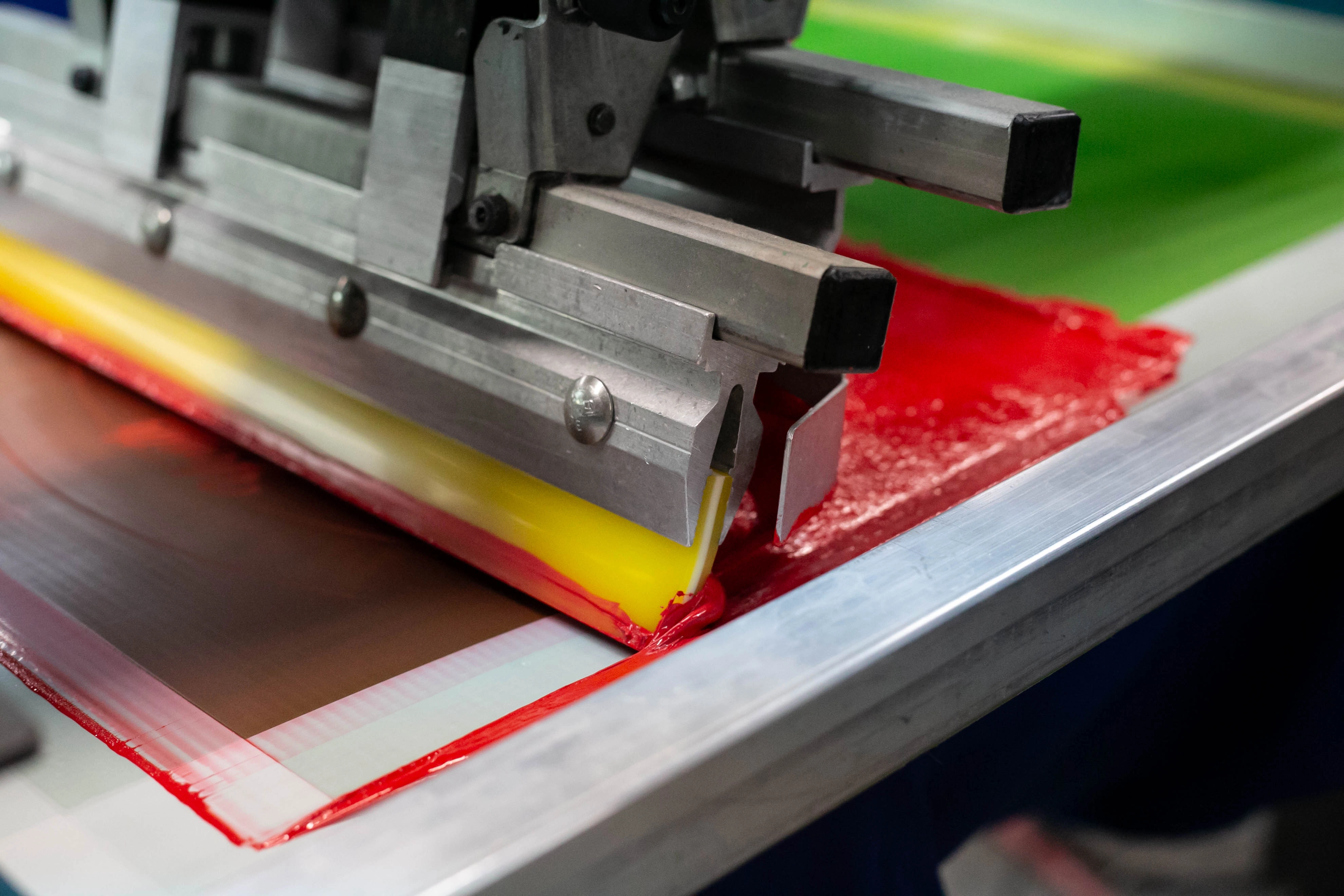 Automatic screen printing press running a bulk apparel order
